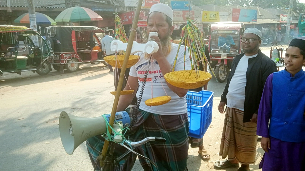এক হাতে সাইকেলের হ্যান্ডেল, অন্য হাতে মাইক্রোফোন—এভাবেই মাইলের পর মাইল পথ পাড়ি দেন শাহাজান হাসান ¦ ছবি: এস আর এ হান্নান