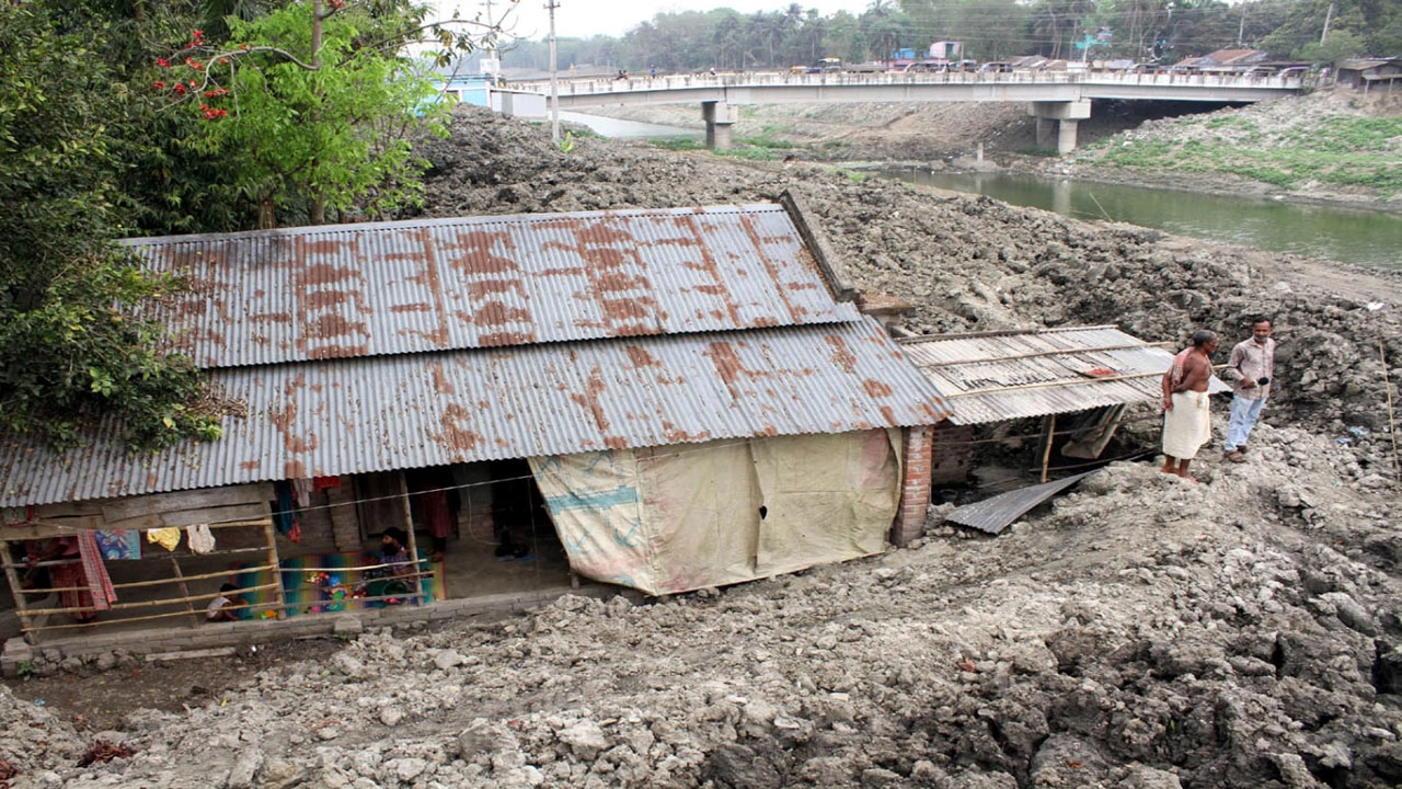 যশোরের বাঘারপাড়ার চিত্রা নদীর খননকৃত মাটিতে অনরুদ্ধ হয়ে পড়েছে দেড় শতাধিক পরিবার। ছবিটি শনিবার খাজুরা ব্রিজেনা দক্ষিণ প্রান্ত থেকে তোলা। ছবি: গ্রামের কাগজ
